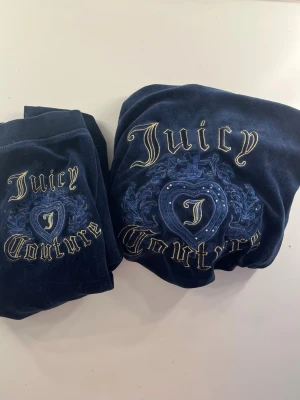 Vintage Mörkblå velourset Juicy Couture💙 - Vintage Juicy Couture loungewear-set i mörkblå velour med broderad logga och hjärtdetalj på både byxor och tröja. Setet har guldfärgade broderier och gnistrande stenar på ryggen. barnstorlek L, jag skulle säga att den passar xs-xxs. Säljer endast som set!