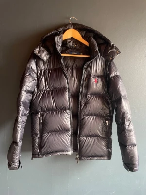 Svart puffer jacket från Ralph Lauren - Vill bli av med en riktigt fet vinterjacka från RL då den är för liten. Jackan har inga defekter och är i nyskick. Priset är inte hugget i sten vilket betyder att ja kan gå ner i pris vid snabb affär! Jackan är M men passar även S