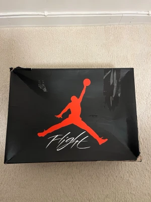 Nike Air Jordan 4 Retro svart/röd - Säljer ett par Nike Air Jordan 4 Retro i svart och rött med klassisk Jumpman-logga på hälen. Skorna har meshpaneler, snörning och en robust sula med synlig Air-enhet. Ovandelen är i mocka och detaljer i plast. Perfekta för dig som gillar streetwear och sneakers med attityd. Passar mindre än 44.