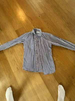 John henric blårandig skjorta - Säljer en blå randig skjorta från john henric, jag på bilden är 178cm lång