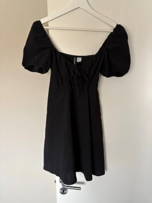 Klänning H&M - Svart klänning med urringning med snörning. Använd flertalet gånger. Säljer pga använde ej längre. Storlek : 34