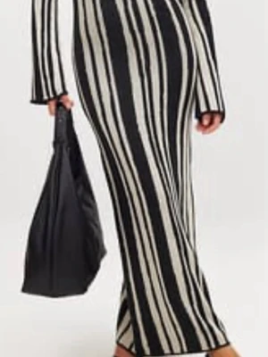 Långrandig stickad klänning - Snygg lång klänning med svart och vit randigt mönster. Klänningen har långa ärmar och figurnära passform. Perfekt för dig som gillar en trendig och stilren look.