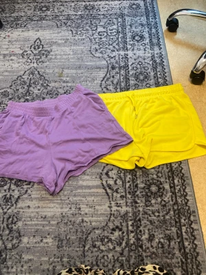 Gula sportiga shorts med snörning - Säljer ett par gula sportiga shorts med snörning i midjan. De har en klassisk loose passform och är perfekta för sommaren. Materialet känns mjukt och bekvämt, troligen bomull eller en bomullsblandning. Snygga att matcha med en enkel t-shirt eller hoodie.