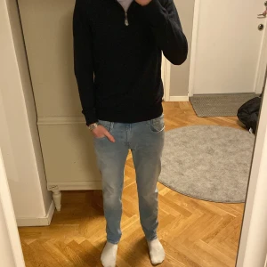 Replay Anbass ljusblå jeans - Säljer ett par Replay Anbassjeans i ljusblå tvätt. De har klassisk femficksdesign, normal passform och raka ben. Midjestorleken är 31 men sitter mer som 30. Materialet är stretchigt jeans för extra komfort. Snygga detaljer med Replay-logga på fickan och bakre läderpatch.