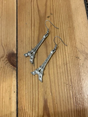 Eiffeltorn örhängen med strass - Säljer ett par silvriga örhängen formade som Eiffeltornet med glittriga stenar. Inköpta i Paris!
