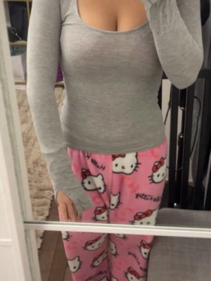 Grå långärmad topp i bomull - Snygg grå långärmad topp med rund halsringning och figurnära passform. Tillverkad i mjuk bomull som känns skön mot huden. Perfekt att matcha med dina favoritbyxor eller myskläder.