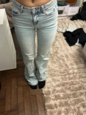 Ljusblå bootcut jeans från Zara - Säljer ett par ljusblå bootcut jeans från Zara i storlek 32. Jeansen har klassisk femficksmodell, hög midja och är tillverkade i bomull med lite stretch. Perfekta för en avslappnad och trendig look.