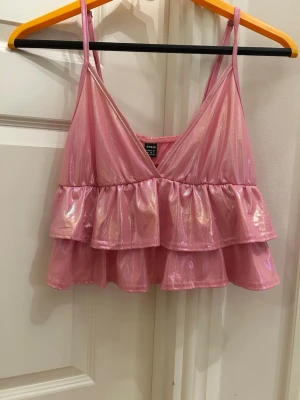 Rosa glittrig volang topp - Säljer en rosa glittrig topp från Shein med dubbla volanger och smala axelband. 