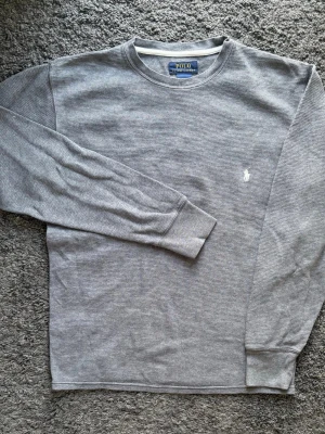 Polo Ralph Lauren | Grå tröja Stl S | Toppskick  - En riktigt snygg och grå tröja från Ralph Lauren. Denna tröja perfekt som basplagg och ger en stilren och väldigt skön look till vardags! 👕 Märke: Polo Ralph Lauren 📏 Storlek & Passform: S 🧵 Material: 100% bomull 📐 Mått: Bröst: 51 cm Längd: 63 cm Ärmlängd: 48 cm ✅ Skick: 9/10 Fint skick, varsamt använd utan defekter! ✨ Detaljer: Vit broderad logga på bröstet. Snygg textur 💰 Nypris: Ca 1200 kr ‼️ Skickas inom 24h ‼️ 