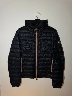  Moncler jacka - Säljer min moncler jacka i storlek 2 skönt till văr/ höst fungerar även bra på en sommarkväll. Finns 2 langningar ena pä ryggen bild 2. Andra lagningen syns nästan inte bild 1 under vänstra bröstfickan. När jackan bärs sắ ser man inte lagningarna. Dragkedjans handtag börjar bli lite defekt men fungerar som den ska.