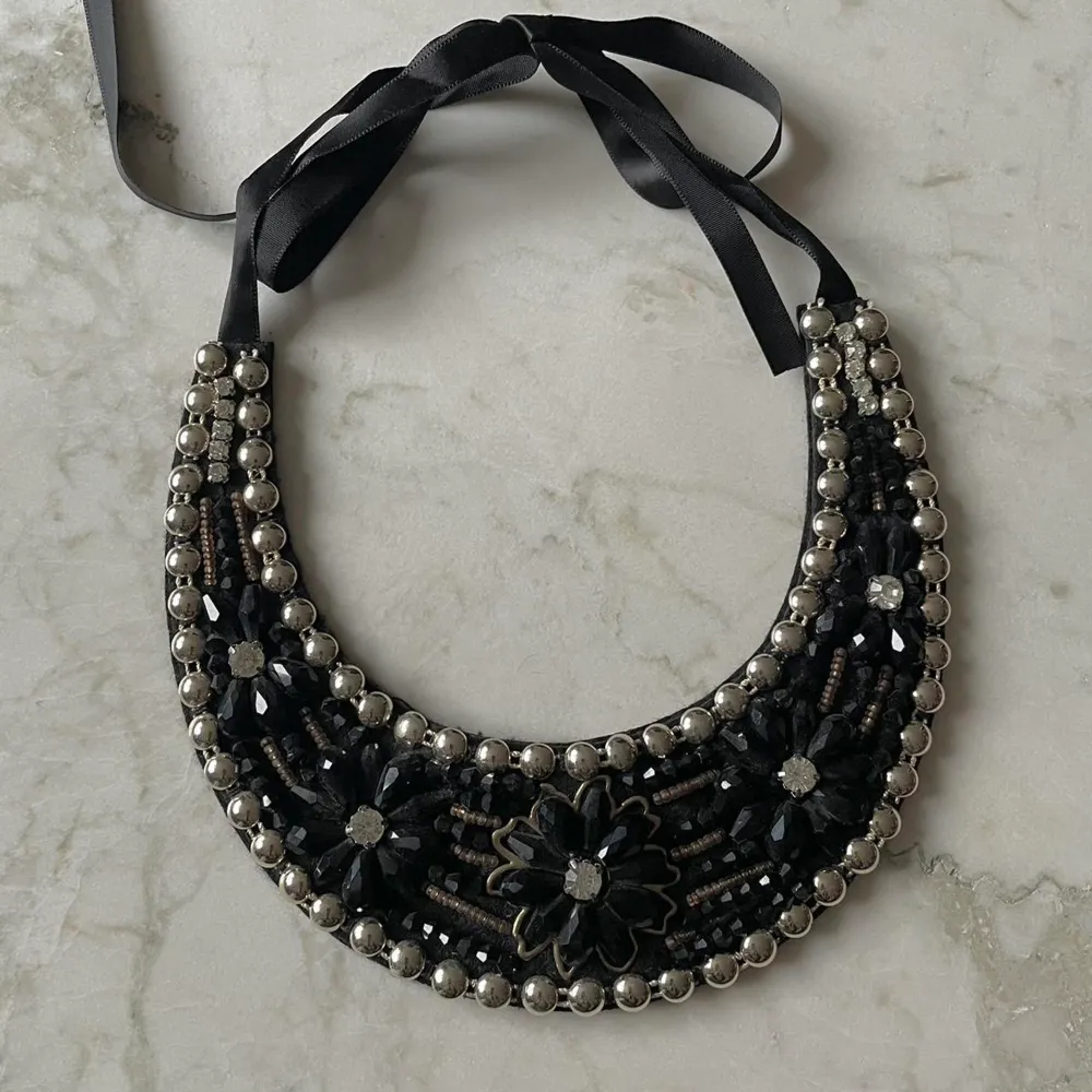 Black Beaded Bib Necklace  Felted Bib sits comfortably, Sequin and Black Beading  gently worn  Adjustable Black Ribbon Closure. Best worn with collared shirt.. Accessoarer.