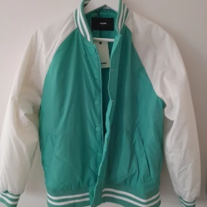Trendig Jacka - Helt ny jacka från BIK BOK  Färgen är ljus grön men man ser inte det på bilden så bra.Den är ganska lätt & passar perfekt till sommaren!   ( Lappen finns fortfarande på, se bild nr 2)  Säljer pga fel storlek Nypris: 499