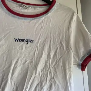 Säljer denna vita wrangler t-shirten med röda och ljusblå detaljer. I storlek s, men skulle säga att den är mer som en xs. Säljer då den är för liten för mig 