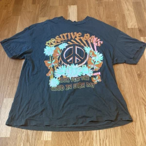 T-shirt  - Superbekväm oversize t-shirt med vackert tryck. Grå svart med färgglada detaljer, bra skick.