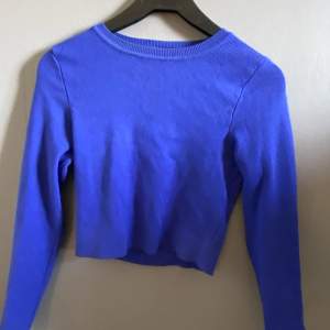 En långärmad tröja, som slutar ungefär vid magen, beroende på längd, jätte fin blå färg  Köpt på Zara