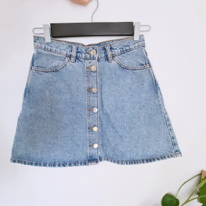 Jeanskjol - Jeanskjol med knäpping. Storlek 36.