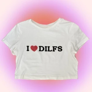 BabyTee - Vit babytee med ”I❤️DILFS” tryck, lite see through och rätt så tajt men med lite stretch. Skulle nog säga att den är liten i storleken så passar mer en mindre M till S💞