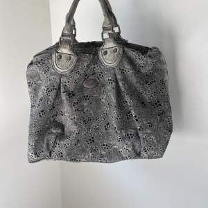 Galet cool väska i grå skiftande färg och unikt mönster. Längre band medföljer. 