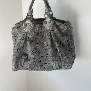 Galet cool väska i grå skiftande färg och unikt mönster. Längre band medföljer. 