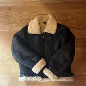 Good Shearling vinterjacka storlek M - Varm jacka till vintern. Jackan är 52 cm bred, armen på insidan är 45 cm, längd fram 56 cm och i bak 59 cm 