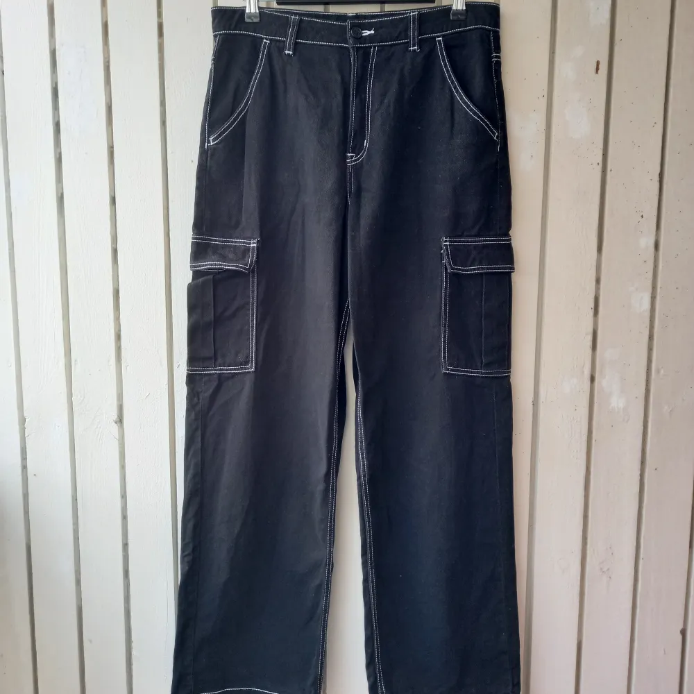 Black pants with wide legs and contrast white stitching. They are high waisted and the legs are longer than average, they are good for platform boots or heels. The fabric is nice thick cotton. Length 108 cm/waist 42 cm/hips 54 cm/size on the label 40 (L). Jeans & Byxor.