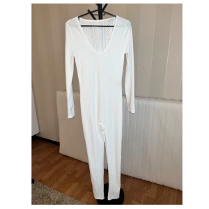 Vitt jumpsuit  - Oanvänt. Fabrik: medium strech  Material: 95% polyester 5% elastan Den är genomskinligt 