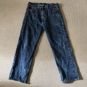 Vintage Levis jeans med eget tryck på fickorna. Storlek 32/32. Bra skick med lite slitage nere vid benöppningen 
