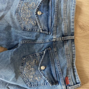 Lågmidjade jeans  - Jätte fina lågmidjade jeans med mönster på bak fickan. Använt ca 5 gånger. Midjemått: 89 cm och innerbenslängd: 81 cm. Jätte söta och långa så perfekt om man är lång eller vill ha lite längre som sitter över skorna. 