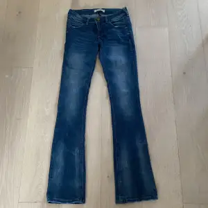 Ett par mörkblå low waist jeans med fin tvätt. Köparen står för frakt.