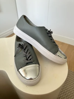 Axel Arigato helt oanvända - Helt oanvända sneakers i grå och silver 