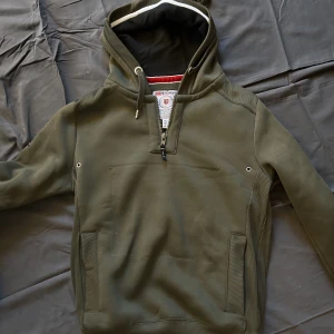 Grön hoodie  - En hoodie med jättefin grön färg. Jag har tagit bort en grej för länge sen och det har lämnat ett märke men annars är den i bra skick. Den är även jättevarm