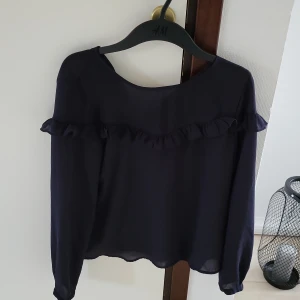 Blus - Blus med volang. Marinblå. 