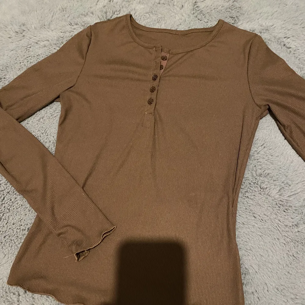 Jättefin brun tröja med knappar i storlek S! Endast testad. Färgen i verkligheten är mest lik bild nummer 2 förutom att det ser rosa ut vid knapparna, vilket det inte gör. Priset går absolut att diskuteras🫶🏻. Tröjor & Koftor.