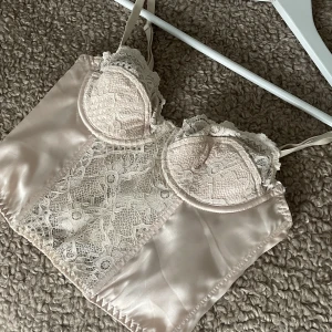 Korsett Urban outfitter - Ljusrosa korsett i satin och spets från Urban outfitters🎀(använd 1 gång)