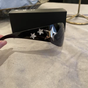 Solglasögon - Ett par as coola solglasögon med silvriga stjärnor på sidan. Aldrig använda. Skriv privat för mer info och bilder.