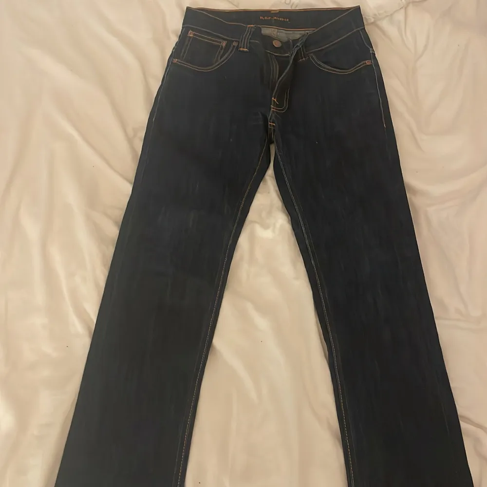 Ett par mörkblåa jeans från nudie ettt dyrt fint märke. Dess byxor är inte använda super snygga men köpte på secundhand. De e raka där nere. Skriv för Mer info. Jeans & Byxor.