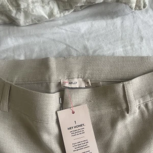 Kostymbyxor  - Säljer dessa beiga kostymbyxor ifrån Nelly som heter Low wide suitpants. Lapp kvar och endast testade 
