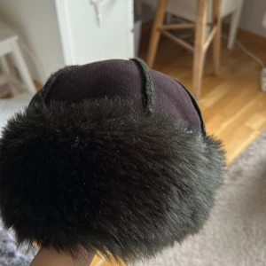 Pälsmössa - Använd flertal gånger, köpt för längesedan. Svart, men kameran visar som att den har gröna toner.