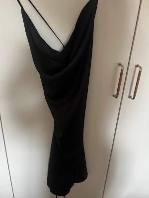 En helt ny svart silke klänning, aldrig använd. Liten i storlek skulle säga 36-38 M