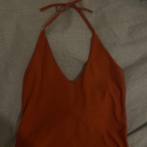 Orange topp - Säljer mitt fina orangea linne. Passar perfekt för sensommar och höst. Säljer då den är för liten för mig. Knyter själv efter sin storlek vid bysten och hur den ska sitta. Har extra tyg vid bysten. Står storlek L men skulle säga att den är en S/M. 