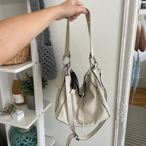 Handväska  - Vit handväska med två olika band och lagom stor förvaring! Så snygg form på väskan och prefekt då den varken är för stor eller för liten🤩 väskan är väl använd med slitningar på en bandet men utöver det i bra skick! Från pull and bear (frakt tillkommer) 