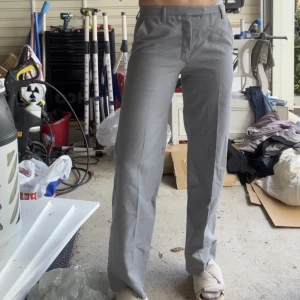 Kostymbyxor  - De perfekta gråa kostymbyxorna som är midrise, breda vid anklarna och har en veckning på framsidan. Jag är 175