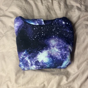 Mjuk rymden luvtröja  - Mjuk luvtröja med rymden och galaxer. Använd 1-2 gånger och är i bra skick. Skön att ha på sig.