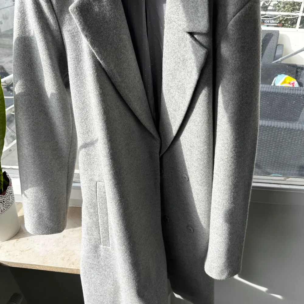 En väldigt fin grå kappa som är från villa. Den är nästan helt ny den är då i ett väldigt bra skick.. Jackor.