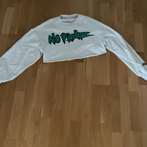 En cropped No fear tröja - En fin vit cropped hoodie,kommer i bra skick. Använd sällan.