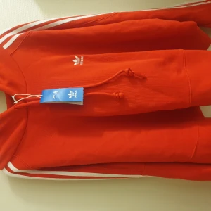 Röd adidas hoodie - En röd adidas hoodie. Den är oanvänd (med etikett- se bilder)