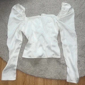 Vit silkestopp - Topp med mindre puffärmar och dragkedja baktill. Använd 1 gång!