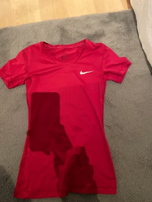 Nike träningströja - Jag säljer denna fina vinröda träningströjan från märket Nike. Den är i bra skick förutom att loggan har spruckit lite.🌸 säljer för 110kr exklusive frakt.