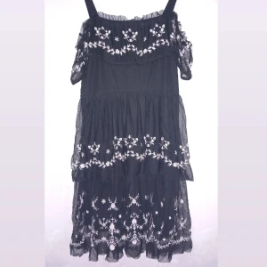 Fin svart blommig klänning! - Svart klänning med vita blommor med 2 kjolar och en underkjol :)