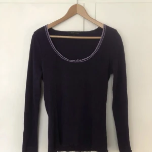 Tröja med spets - Tröja med lila spets och en liten rosett. Väldigt vackra detaljer!! Passar down town girl stilen och påminner mig om gilmore girls.